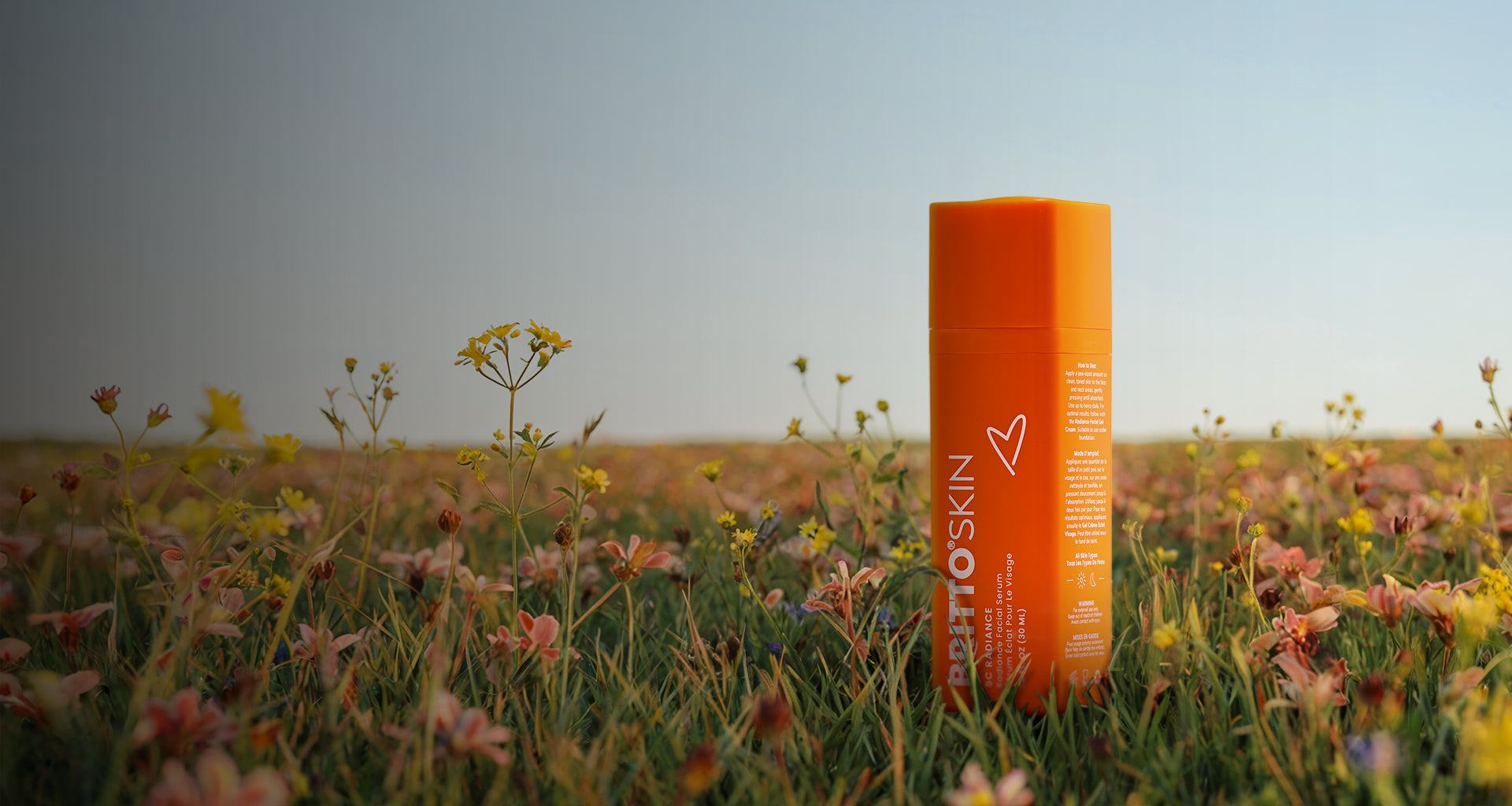 A Vibrant photo of a 5C Radiance Facial Serum on a field of flowers