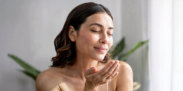 A woman gently washing her face