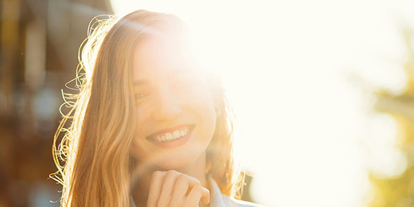 A Woman smiling with the sun behind her