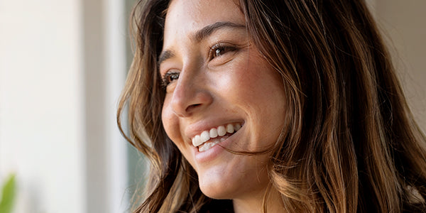 A woman smiles with a radiant skin
