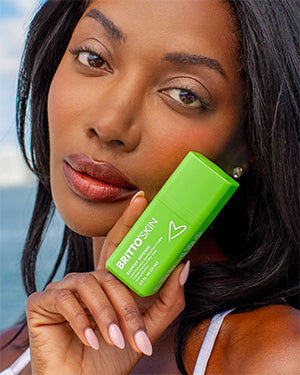 A woman holds the Barrier Defense eye cream in her hand.
